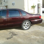 Before and after photographs of a damaged Chevy Impala that was repaired by Elite Paint & Body Shop in West Palm Beach, Florida.